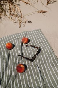 Kaboompics - Peaches and Sunglasses on a Striped Beach Towel