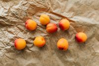 Kaboompics - Ripe Apricots Scattered on Crumpled Kraft Paper, Rustic Summer Fruit Background for Recipes