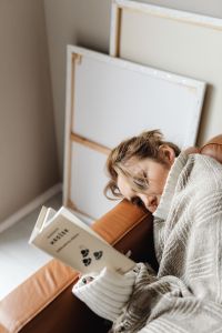 Kaboompics - Woman Reading a Book While Cocooning on the Sofa