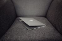 Kaboompics - Close up view of closed laptop lying on grey armchair