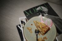 Kaboompics - Cake Slice with Pink Number Candle and Magazines