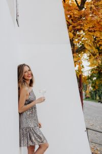 Kaboompics - Woman Peeking around White Wall with Champagne in Autumn