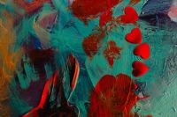 Kaboompics - Red Foil Heart Confetti on Colorful Abstract Paint Background