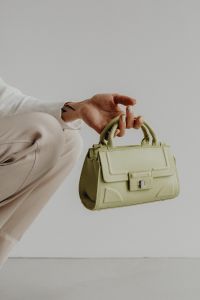 Kaboompics - Woman Holding Sage Green Structured Handbag in a Neutral Fashion Editorial