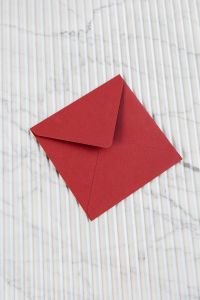 Kaboompics - Red Envelope Centered on Striped Marble, Vertical Stationery Mockup