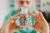 Kaboompics - Doctor Examining Pills and Medicine Bottle