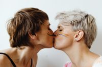 Kaboompics - Women Kissing with Rainbow Pride Face Paint on White Background