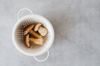 Kaboompics - White Colander of Boletus Mushrooms With Copy Space