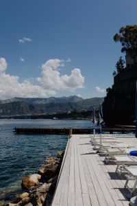 Kaboompics - Sorrento Seaside Deck With Blue Umbrellas And Mountain View