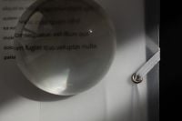 Kaboompics - Glass Sphere Magnifying Printed Text Through Translucent Folder