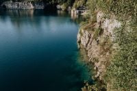 Kaboompics - Dark Blue Water and Autumn Leaves Beside a Cliff