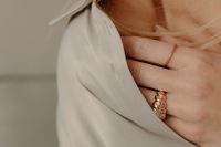 Kaboompics - Woman's Hand Touching Gold Ring on Tan Silk Shirt