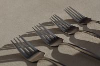 Kaboompics - Modern Steel Forks Arranged with Long Shadows on Neutral Surface