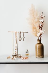 Kaboompics - Minimal White Marble Vanity with Jewelry Stand, Perfume and Dried Pampas Stem, Vertical Copy Space
