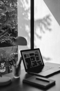 Kaboompics - Monochrome Laptop Workspace with White Desk Lamp and Pencil Cup beside a Bright Window