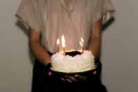 Kaboompics - Woman Holding a White Birthday Cake with Lit Candles