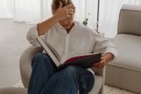 Kaboompics - Close-Up of Woman Reading in a Neutral Armchair