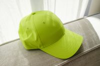 Kaboompics - Lime Green Baseball Cap on a Neutral Sofa
