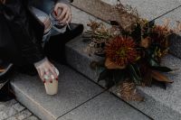 Kaboompics - Woman Holding Takeaway Coffee Beside an Autumn Bouquet on Steps