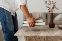 Kaboompics - Woman Returning Books to a Marble Coffee Table