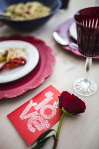 Kaboompics - Red Wine Glass, Rose and Love Card at Elegant Dinner Table