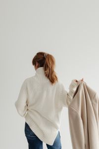 Kaboompics - Faceless Woman Holding Beige Coat Beside White Sweater