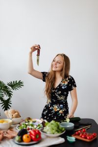 Kaboompics - Smiling Woman Holding Up a Kitchen Knife during Salad Preparation