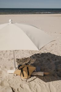 Kaboompics - White Umbrella Casting Shade over Beach Bag and Textiles