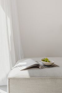 Kaboompics - Sunlit Reading Nook with Open Magazine and Green Grapes