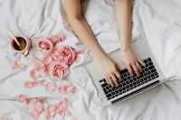 Kaboompics - Woman Working from Bed with Laptop, Coffee and Pink Roses