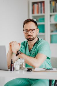 Kaboompics - Doctor Seated Beside Laptop in Office