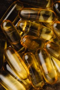 Kaboompics - Close-Up of Golden Softgel Capsules on a Dark Background