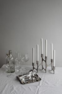Kaboompics - Glassware, Bottle, Chrome Candelabra and Jewelry on White Tablecloth