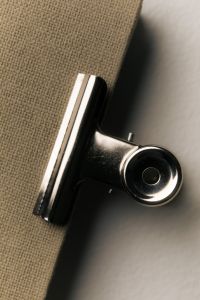 Kaboompics - Black Binder Clip on Textured Notebook