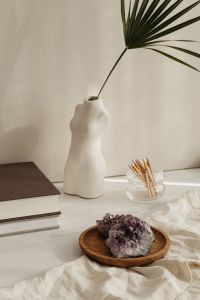 Kaboompics - White Buddha And Torso Vase With Matchsticks On Books