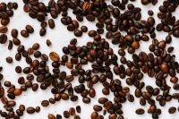 Kaboompics - Overhead Roasted Coffee Beans Scattered Across White Texture for Food Styling