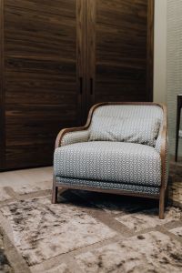 Kaboompics - Patterned Upholstered Armchair in Front of Dark Wood Wardrobe