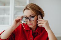 Kaboompics - Close-Up Woman Adjusting Eyeglasses while on Smartphone