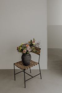 Kaboompics - Small Vase on Woven Stool Against a Plain Interior Wall