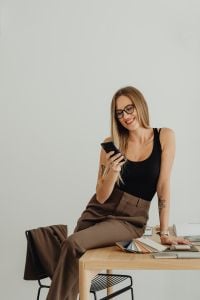 Kaboompics - Woman Sitting on Table While Looking at Phone