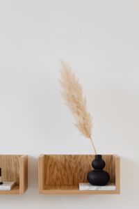 Kaboompics - Dried Grass in Black Sculptural Vase on Wooden Floating Shelf