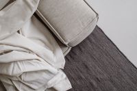 Kaboompics - Close-Up White Linen on Neutral Sofa and Dark Rug – Fujifilm X100VI