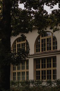 Kaboompics - Large Arched Windows on a Historic Building Behind Trees