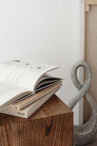 Kaboompics - Open Book on Walnut Cube Table with Sculptural Decor and Copy Space