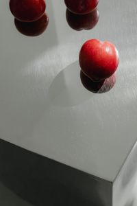 Kaboompics - Close-Up Red Plums on Reflective Chrome Tabletop