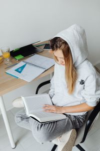 Kaboompics - Teen Student Reading Textbook in Home Study Space