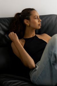 Kaboompics - Woman Sitting on Black Leather Chair Wearing Gold Earring