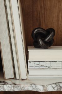 Kaboompics - Black Knot Sculpture and Design Books on a Walnut Shelf