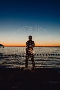Kaboompics - Light painting. The man waving fairy lights at the sea at sunset.