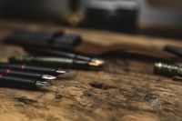 Kaboompics - Fountain Pens in Soft Focus on a Rustic Workbench